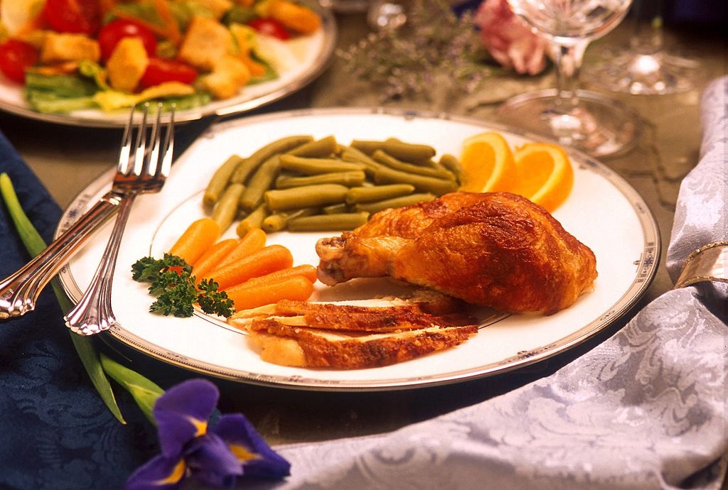 An attractive dinner setting with Chicken, green beans and carrots on a plate